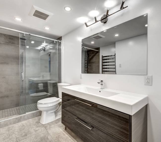 Sleek, contemporary bathroom design featuring walk-in shower and floating vanity by Bathroom Renovations North Shore.